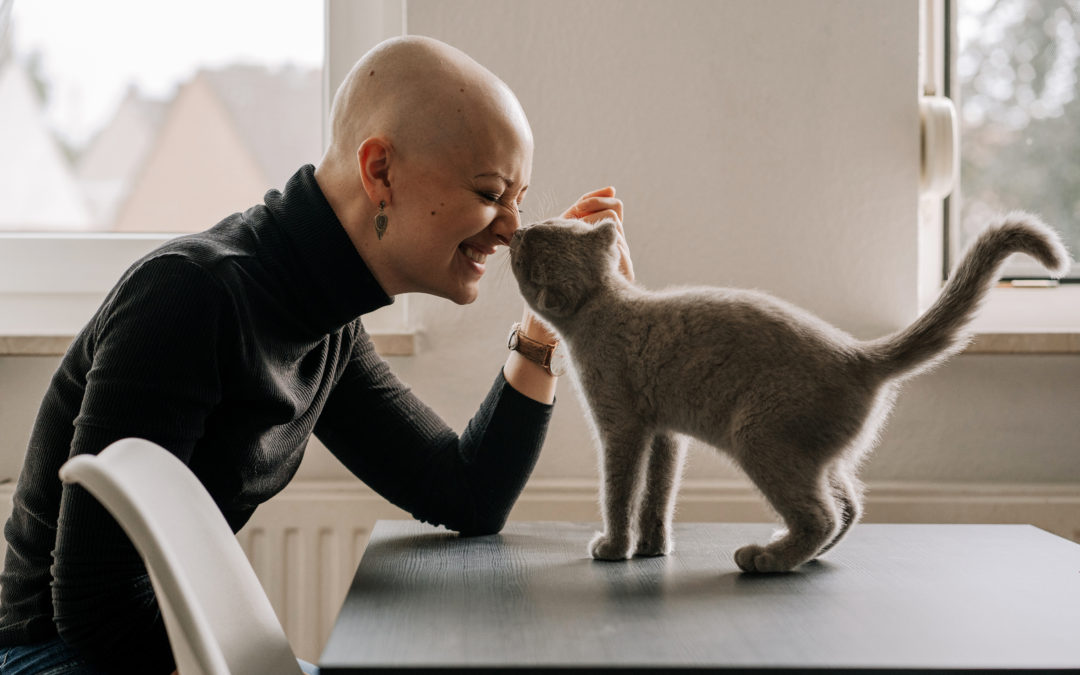 strong woman fighting breast cancer plays with cat at home mt auburn obgyn
